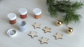 The process of painting wooden Christmas decoration - five stars. Decoupage process. Preparation for New year or Christmas concept background video footage. Selective focus, top view