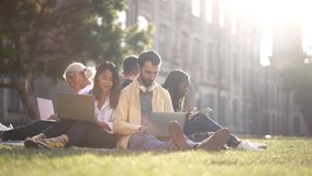 Multinational college mates preparing for lessons while sitting with laptops and tablet on green grass of campus lawn. Multi-ethnic students doing their homework together in nature on sunny autumn day - Powered by Shutterstock - Get 15% off with code: PIKWIZARD15