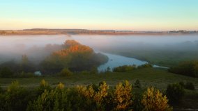 Top down view of a winding river and fog rolling across the plain. Bird's eye view. Location Horyn river, Ukraine, Europe. Cinematic aerial shot. Discover the beauty of earth. Filmed 4k, drone video.