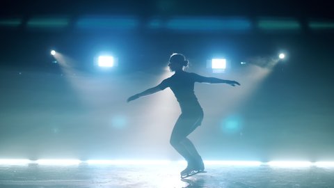 Young girl is performing a spinning element on the skating rink