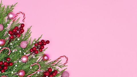 Pink red Christmas decoration on pine tree with Santa's candies on pink theme. Stop motion