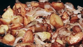 Potatoes with onion are frying in oil.Closeup view.Roasted baby potatoes in iron skillet.Fried crispy potatoes in a pan.Cooking delicious potatoes fries in hot oil.Unhealthy and oily food. Fast food. - Powered by Shutterstock - Get 15% off with code: PIKWIZARD15