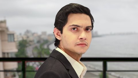 Successful rich millionaire Indian businessman, with defocused background of world famous marine drive queens necklace view from rooftop of luxury penthouse. 4K ProRes 