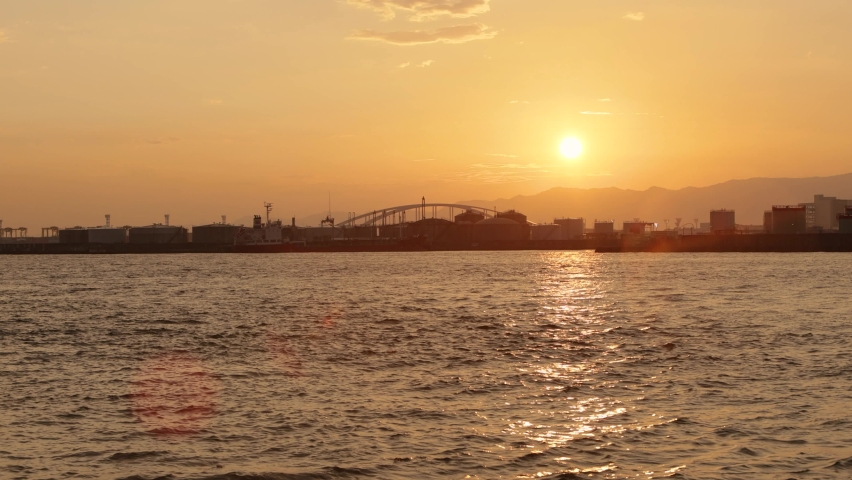 Beautiful sunset over the Yumeshima Bridge seen from Osaka Port. | Shutterstock HD Video #1080953312