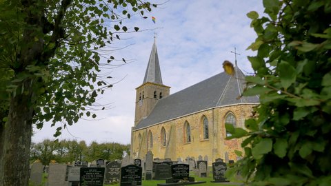 Old Gothic church in The Netherlands. The small village Boksum in Friesland is waving the rainbow flag during coming out day in 2021.