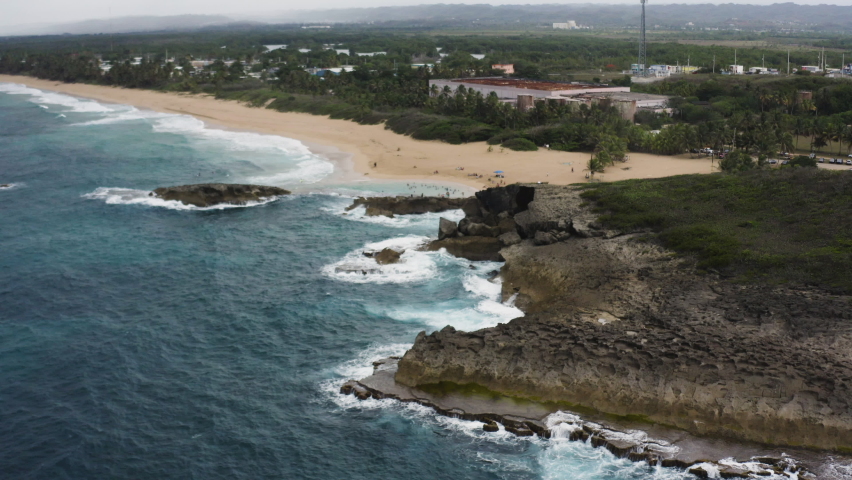 Swell Hitting Rocky Coast of La Poza del Obispo Beach, Public Beach In Arecibo, Puerto Rico. - aerial approach