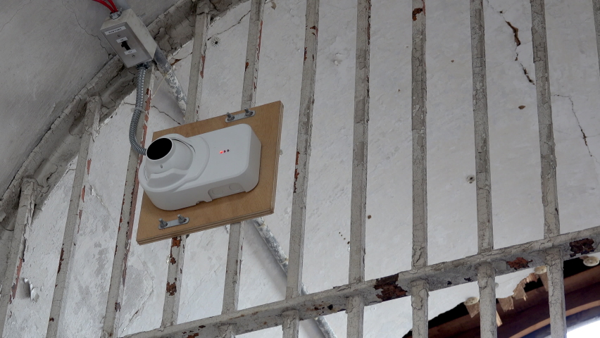 Security camera mounted on bars in prison.