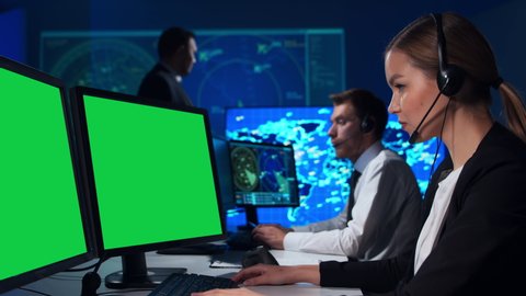 Workplace of the air traffic controllers in the control tower. Diverse team of professional aircraft control officers works using radar, computer navigation and digital maps. Chroma key green display.