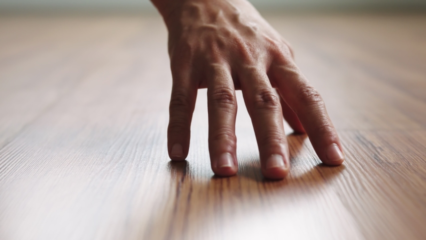 Close up hand of woman dragging on clean wooden laminate floor, Slow motion, Fashionable living.