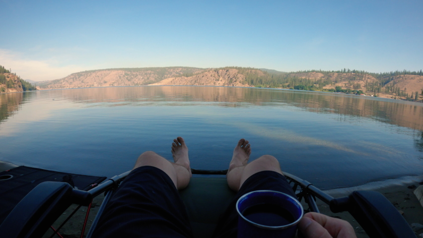 Lake Shore Camping Chair Drinking Coffee First Person View Perspective. Peaceful lakeside relaxation spot with calm water reflecting Eastern Washington landscape | Shutterstock HD Video #1080962006