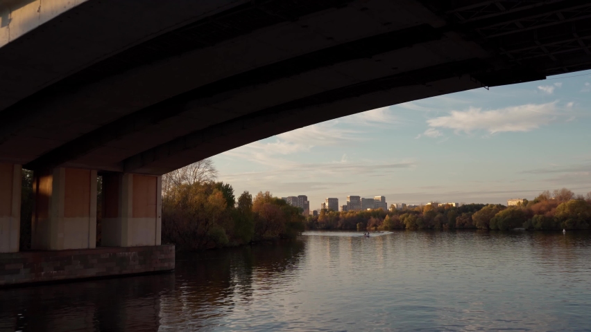 Autumn. View from the side of a pleasure boat sailing along the river and canals of Moscow at the setting sun and trees with yellowed foliage.