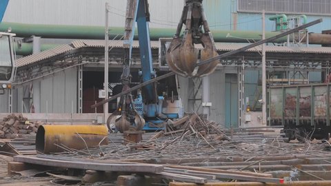 Recycling metal waste, metal recycling yard. Recycling of metal. Excavator with grab