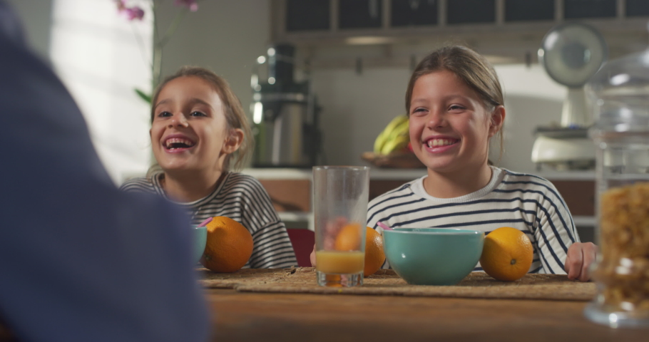 Family Having Fun at Breakfast: Parent and Daughters Making Funny Faces with Oranges. Playful Female Children Laughing While Having Essential Healthy Breakfast. Concept of Growing Up and Childhood Royalty-Free Stock Footage #1080966074