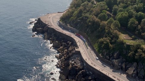 Beautiful coastal road on rocky cliffside, tropical coastline, aerial drone view