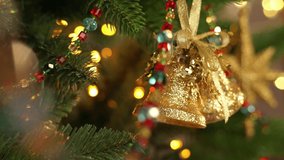 Camera movement on Christmas decoration bell on branch of Christmas tree on background of shining lights of golden garland. New Year holiday celebration - Powered by Shutterstock - Get 15% off with code: PIKWIZARD15