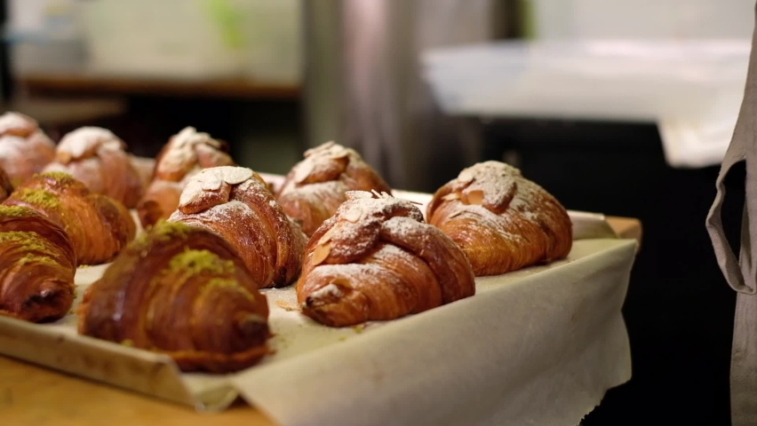 Baked croissants sprinkled with powdered sugar using sieve Royalty-Free Stock Footage #1080969878