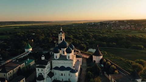 Aerial view of a large church at sunset. The church stands next to the forest