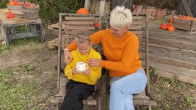 mom and daughter are resting and enjoying an autumn day outdoors in sun loungers, picnic in nature in autumn, mom and daughter are drinking hot tea sitting in a sun lounger. High quality 4k video