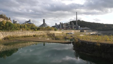 Abandoned Dutch Cement industry factory at chalk and limestone quarry in Limburg, the Netherlands with beautiful colored lake