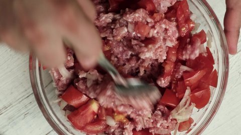 Raw minced meat, onions and tomatoes are kneaded to make the filling for cooking.
