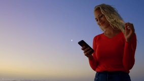 Animation of network of connections over woman using phone on the beach