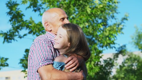 Old man stretches arms to catch teenage granddaughter in hugs and both grandfather and girl feel happiness after long coronavirus quarantine restrictions