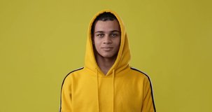 Man laughing over yellow background