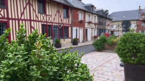 Beuvron en Auge, France - August 3, 2021: Young man entering a house of Beuvron-en-Auge, one of the most beautiful villages in France, is a commune in the Calvados department and Normandy region.