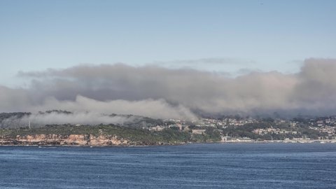 4k, 30fps timelapse of dense fog and low clouds in the Sydney Harbour area at Middle Head and Balmoral Beach in Mosman, a Sydney suburb in New South Wales, Australia. Manly ferries in the foreground.