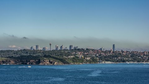 Shot in 2021: 4k, 30fps timelapse of fog and low clouds over Sydney CBD. Sydney Harbour in the foreground at Middle Head and Balmoral Beach in Mosman, a Sydney suburb in New South Wales, Australia.