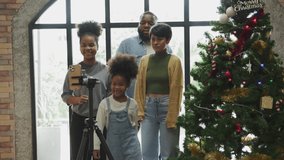 African American family have fun on holiday or Christmas at home. Parents and children making dancing video for social media. Together they create new content online.