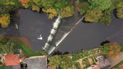 Aerial top down drone footage of the beautiful village of Knaresborough in North Yorkshire in the winter time showing the River Nidd which has two small water falls with houses on the river bank