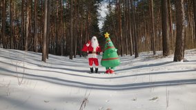 Santa Claus with a woman dressed in doll inflatable Christmas tree costume happily and funny dancing, jumping in winter park on Christmas Eve - Powered by Shutterstock - Get 15% off with code: PIKWIZARD15