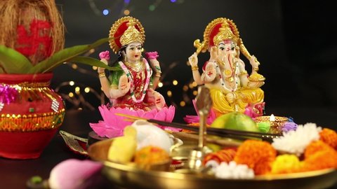 Hands Of Girl In Bangles Holding Clay Diya Deep Dia Lamp Illuminated With Pooja Thali, Flowers, Mithai, Agarbatti And Doing Aarti. Diwali Puja , New Year, Deepawali Or Shubh Deepavali Theme
