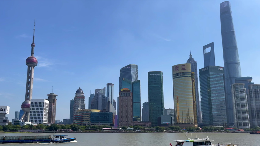 Boats on the Huangpu River passing the iconic Shanghai Lujiazui city skyline in the day time, view from the Bund, Chinese characters translate as Aurora  Royalty-Free Stock Footage #1081035989