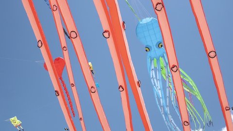 Big inflatable colorful octopus Kites with bright colors and long tails. Heart kite and sponge Bob together flying in the sky. Closeup. International Kite Festival Kelantan, Malaysia 3 June 2016