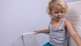 Loopable video f baby girl spinning back and forth in an office chair