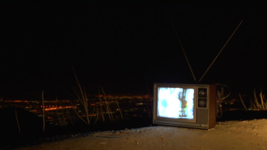 retro TV sitting on the dirt at night