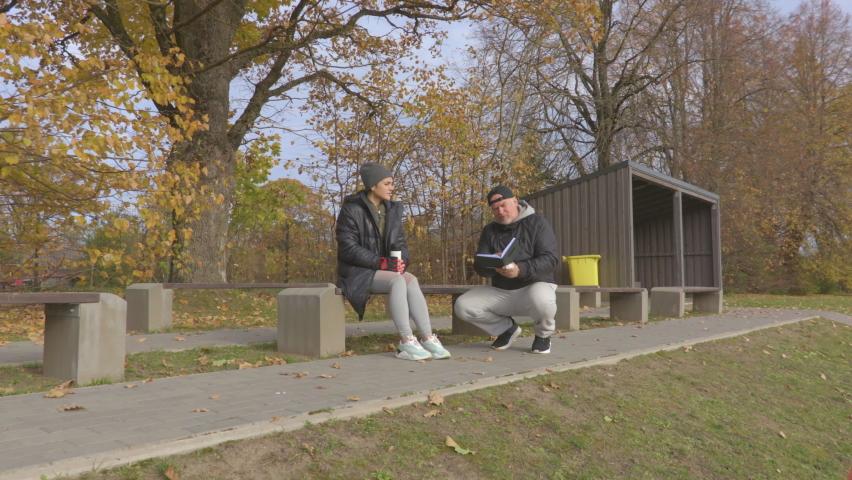 Coach explaining notes and give motivation for sporty woman on stadium