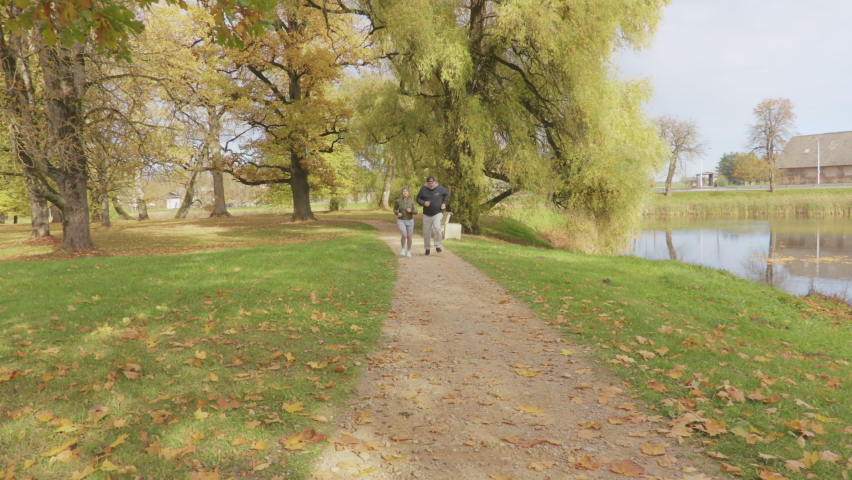 Couple running and woman gets leg injury on path.Sport injury concept


