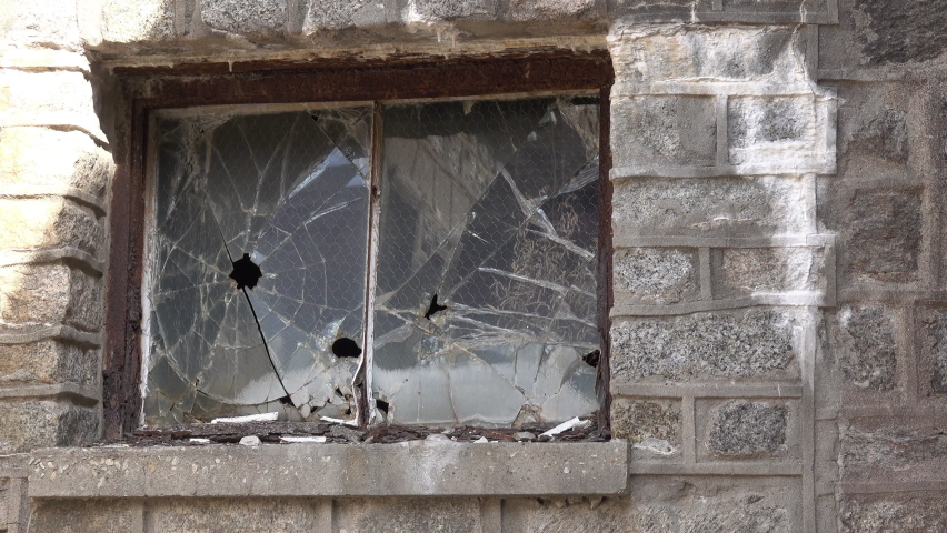 Damaged security glass windows on abandoned building.