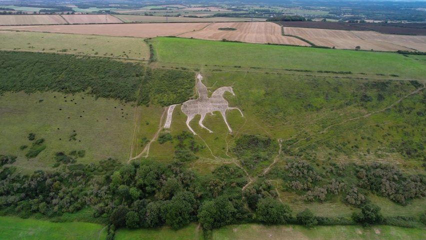 Osmington White Horse historical chalk figure art on hillside slope aerial view push in tilt down