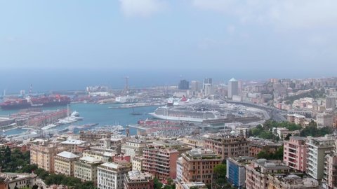 Genoa , Australia - 10 12 2021: Massive cruise and industrial vessel in port of Genoa with cityscape view, aerial