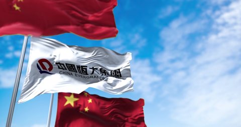 Guangzhou, China, October 2021: The flags of the Evergrande Group and China waving in the wind. Three flags. Evergrande is the second largest property developer in China by sales