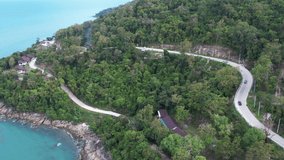 Aerial drone shot top view car driving on road trip route seaside mountain in Khanom, Nakhon Si Thammarat, Thailand.Beautiful island with stunning nature coastal road.Video color nature travel concept