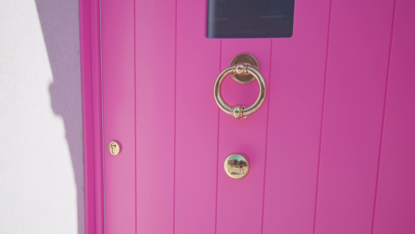 Doorknob and peephole on bright pink door of house in Burano