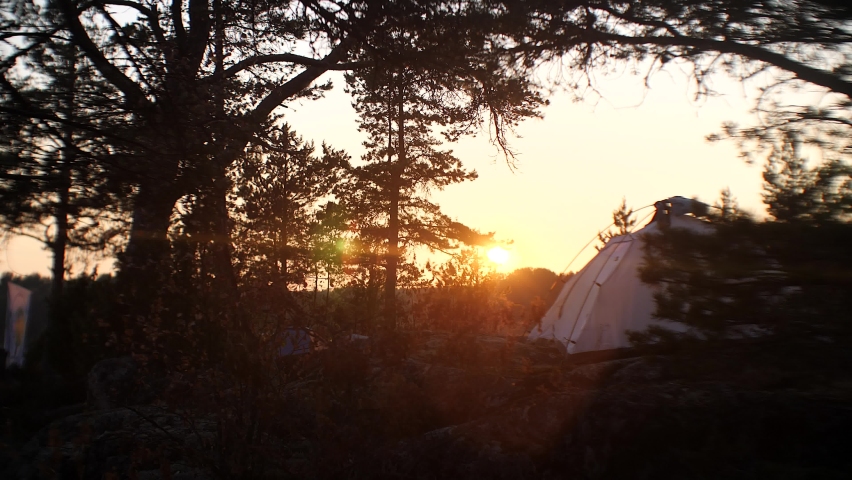 Calm surface of the lake.Tourist tent. Sun glare. 