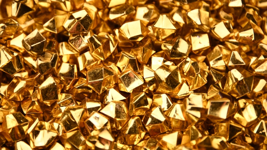 Abstract background of colorful bright golden nuggets spin and flicker, 4K