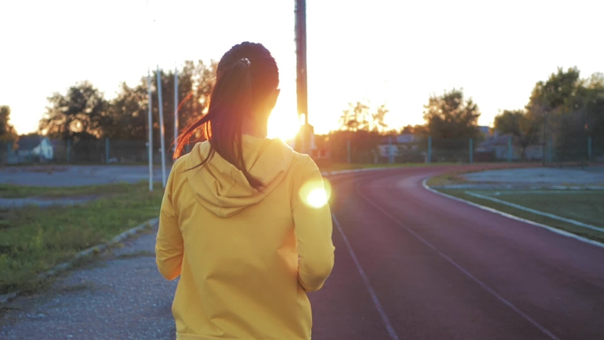Sportswoman. Female athlete jogging, training before marathon competition on sports track of stadium. Sport running fitness healthy lifestyle active stadium workout exercise.