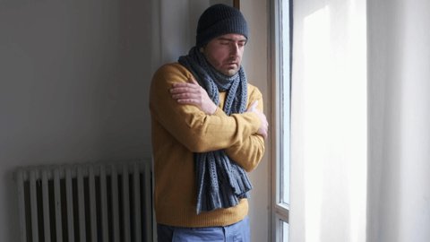 Video about one man feeling cold at home after home heating trouble.The shot gets slowly closer to the subject.